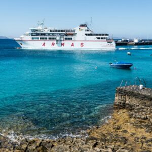 Ferry leaving the harbour in a clear blue water in the canary islands