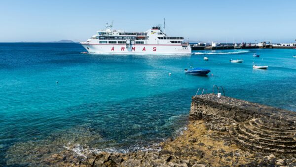 Ferry leaving the harbour in a clear blue water in the canary islands
